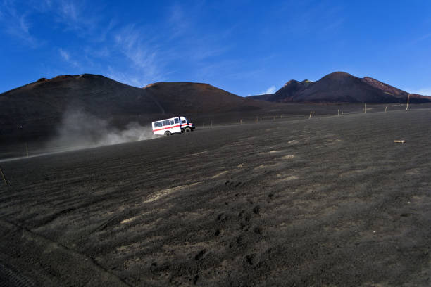 a mountain service car climbs a lava hill on the volcano Etna