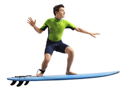 Teenager in a wetsuit surfing isolated on white background