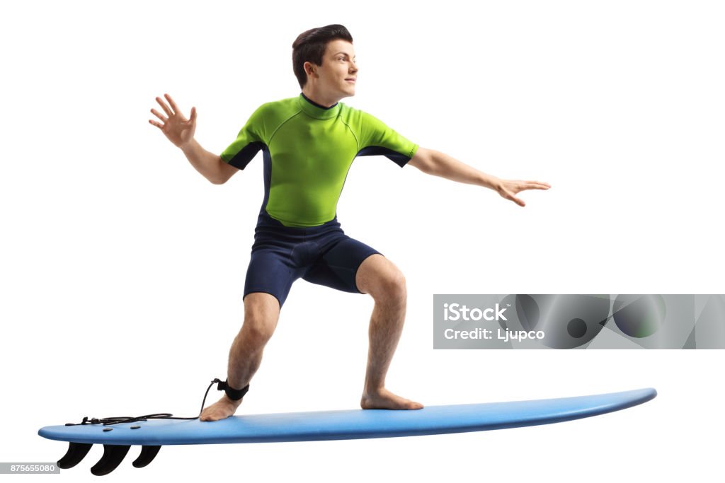 Teenager in a wetsuit surfing Teenager in a wetsuit surfing isolated on white background Surfing Stock Photo