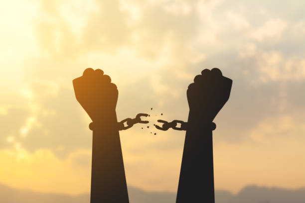 silhouette hand with chain is absent silhouette hand with chain is absent and blurred sky in sunrise background freedom stock pictures, royalty-free photos & images