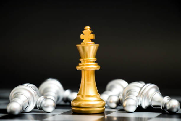 istock Gold king in chess game face with the another silver team on black background (Concept for company strategy, business victory or decision) 875658588
