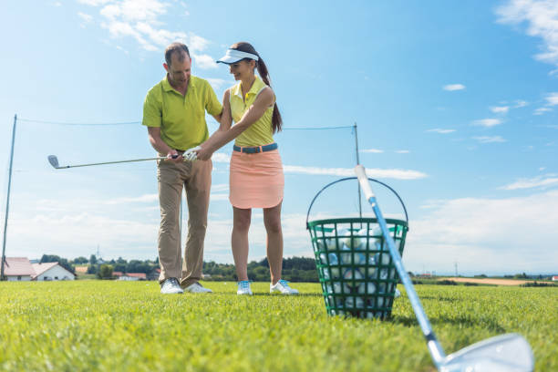 istock Cheerful young woman learning the correct grip and move for using the iron golf club 875663500