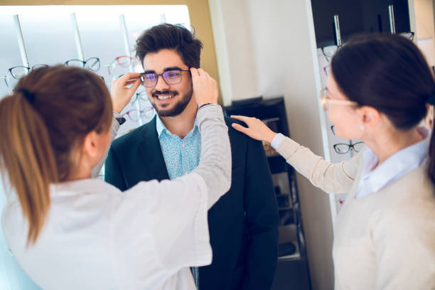 istock Smiling couple selecting eyeglasses in optican store 875666100
