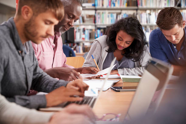 istock Group Of Mature College Students Working On Project In Library 875669214