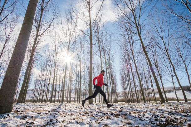 Man running on the snow in a winter day in a forestMan running on the snow in a winter day in a forest