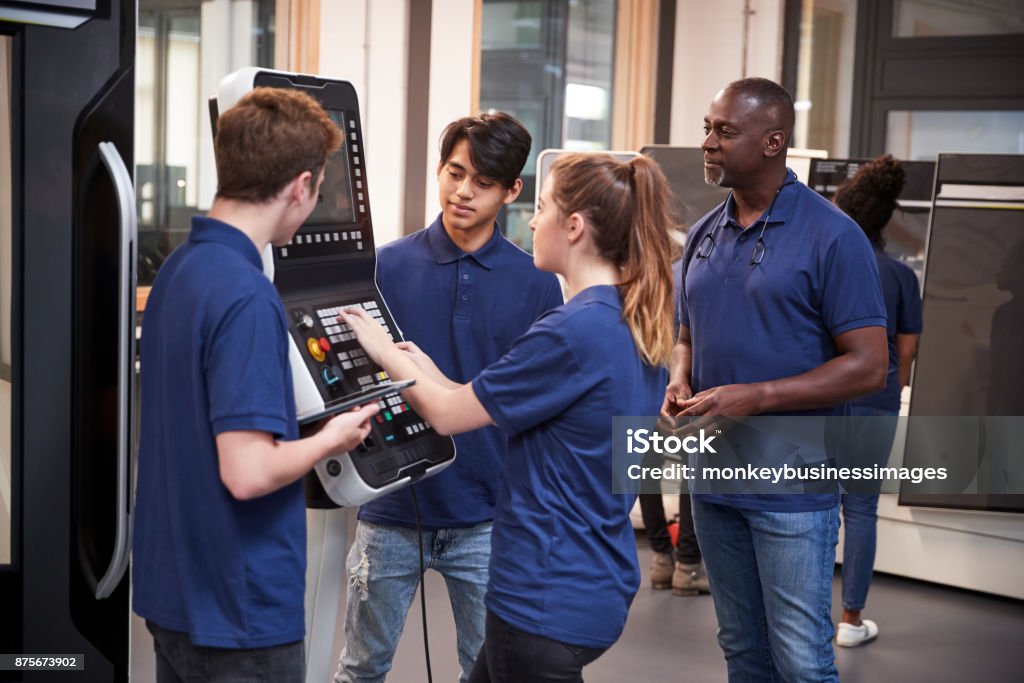 Engineer Showing Apprentices How To Use CNC Tool Making Machine Trainee Stock Photo