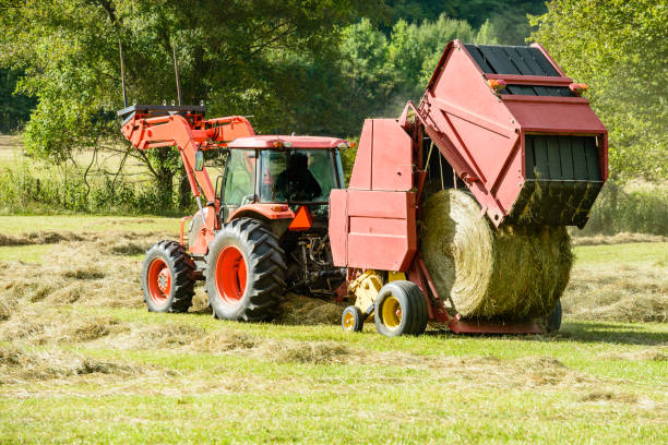 New bale of hay being made A new bale of hay is just coming out of the baler. hay baler stock pictures, royalty-free photos & images