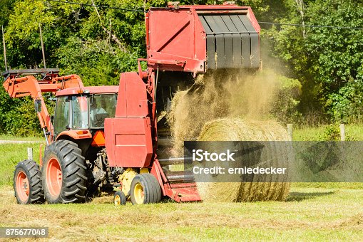istock Hay baler dumping a bale of hay 875677048