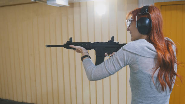 istock Woman shooting with a Mashin gun in shooting gallery 875681322