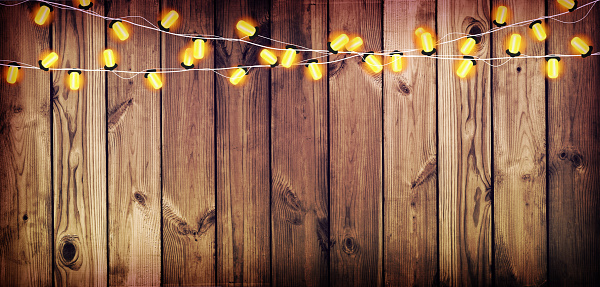 Holiday Lights on the old wooden background. The atmosphere of the holiday. Christmas party. New Year background.