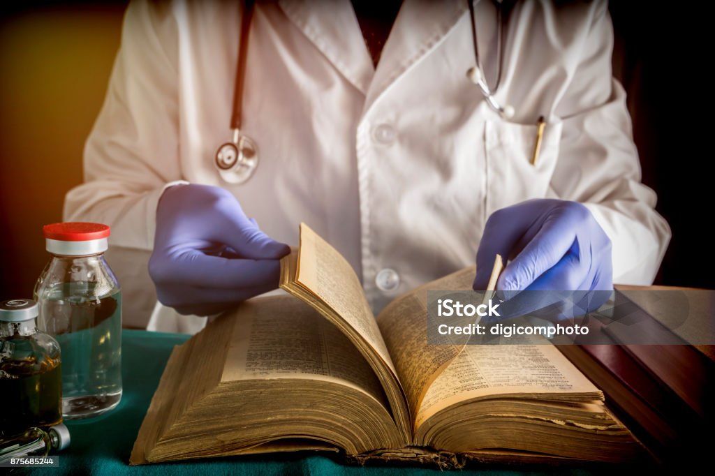 Doctor reading book of old medicine, conceptual image Adult Stock Photo