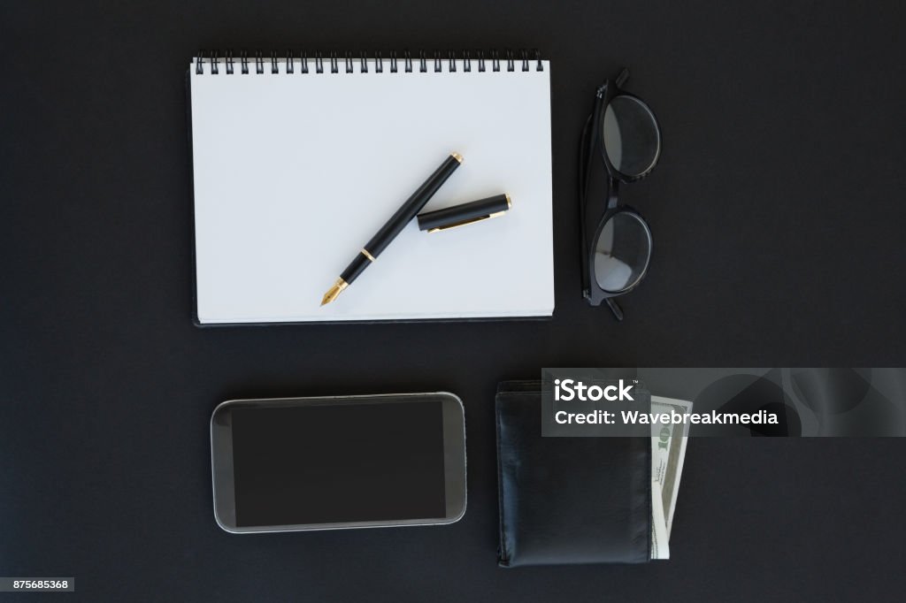 Spectacles, organizer, pen, mobile phone and wallet on background Overhead of spectacles, organizer, pen, mobile phone and wallet on background Backgrounds Stock Photo
