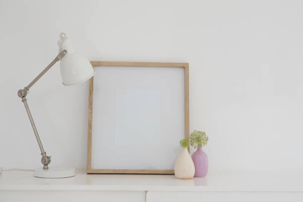 istock Electric lamp, vase and blank picture frame on table 875688588