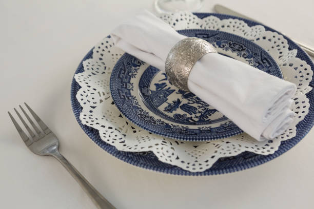 istock Fork, napkin and lace placemat arranged on white background 875689790