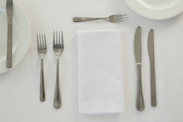 istock Cutlery with napkin arranged on white background 875690336