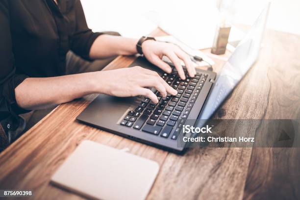 Young Woman Sitting At Rustic Wooden Table Working With Notebook Computer Stock Photo - Download Image Now