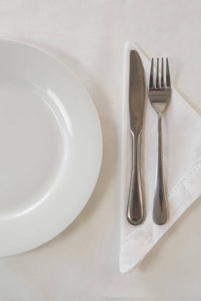 istock White plate and cutlery set on a table 875693666