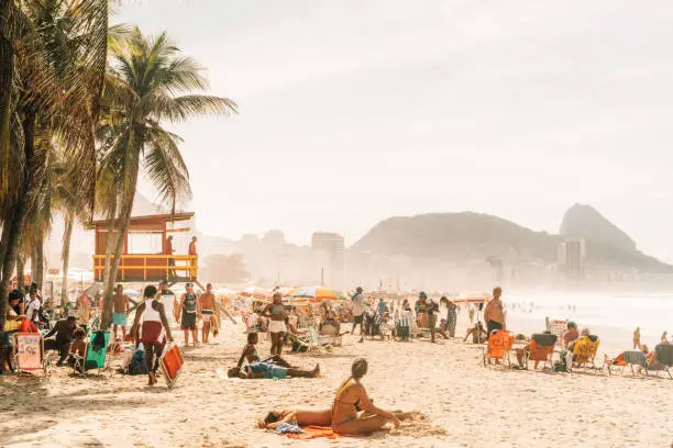 people relaxing and sunbathing at famous Copacabana beach, Rio de Janeiro, Brazil