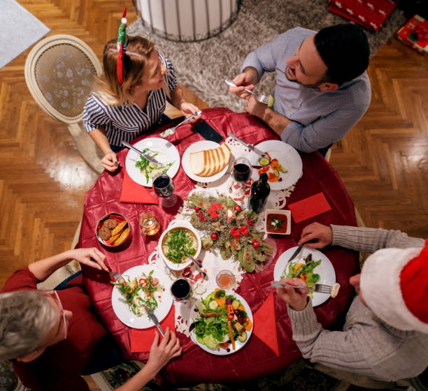 istock Top view of the table while family celebrating Christmas together. Group talking while having lunch. 875696548