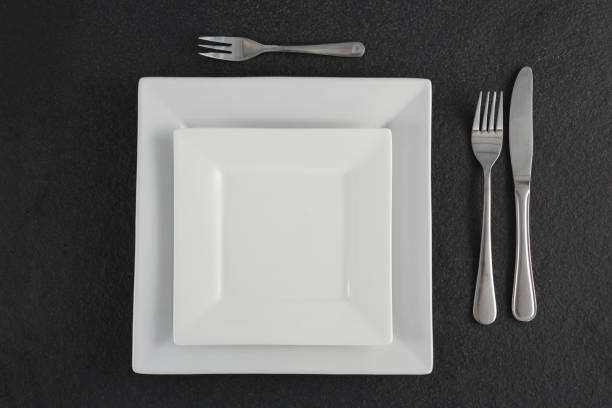 istock Square plates and cutlery set on a table 875696938