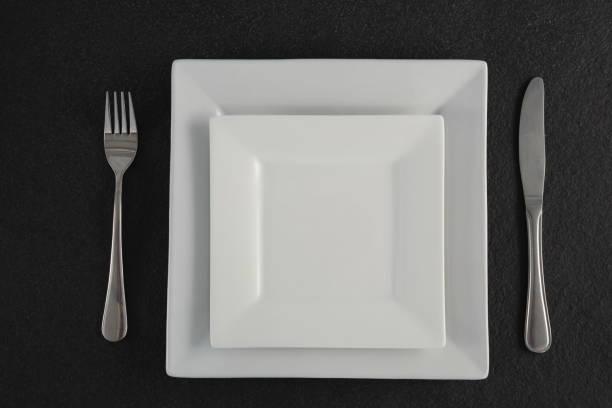 istock Square plates and cutlery set on a table 875696962