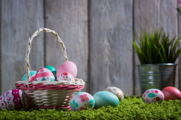 istock Easter eggs painted on a wooden background of boards on green grass. 875700428