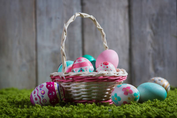 istock Easter eggs painted on a wooden background of boards on green grass. 875700576