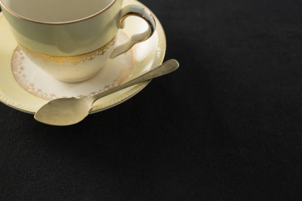 istock Empty cup with saucer and spoon on black background 875704118