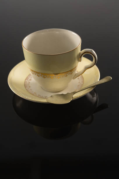 istock Empty cup with saucer and spoon on black background 875704168