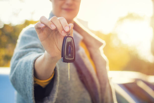 istock Woman with new car key. 875710646