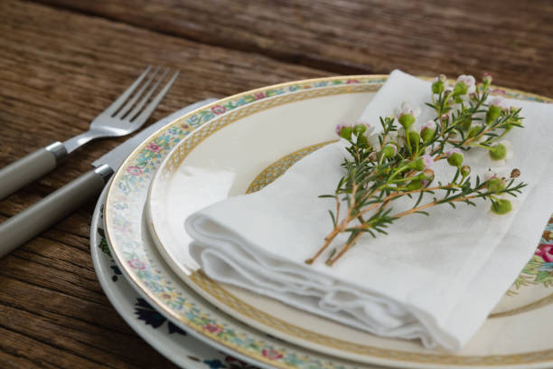 istock Fork and butter knife with napkin and flower arranged in a plate 875711098