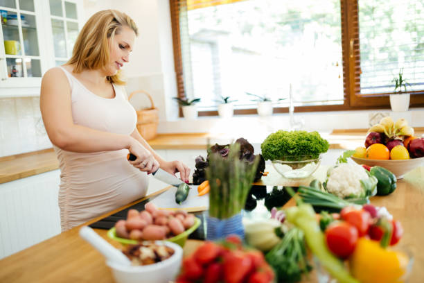 istock Pregnant woman making a meal in kitchen 875711596