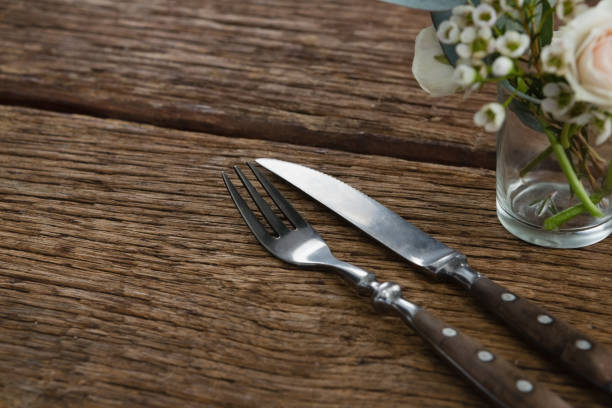 istock Fork and butter knife with rose flower n wooden table 875717966