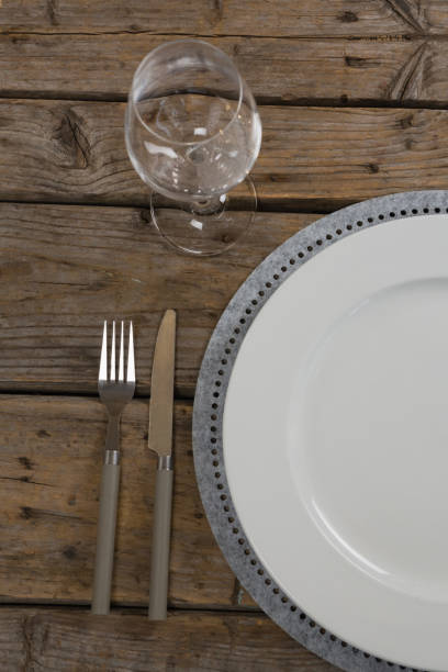 istock Plate and wine glass with fork and butter knife on wooden table 875720814
