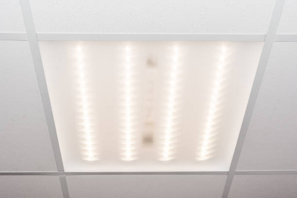 ceiling of square porous plates and built-in LED lamp stock photo