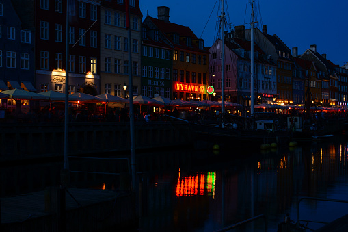 Copenhagen, Denmark - July 28, 2017: night scene 17th-century waterfront Nyhavn (New Harbour), new port of Copenhagen. Colorful old town architecture. Copenhagen boats, European street