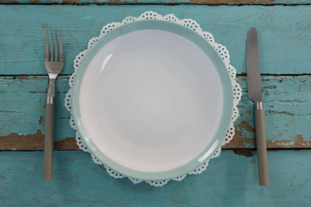 istock Plate with fork and butter knife on wooden table 875722358