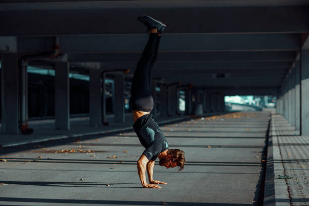 istock Young man doing hand stand in the urban environment 875739448