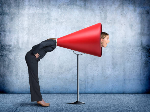 istock Businesswoman Sticks Her Head Into A Large Red Megaphone 875739984