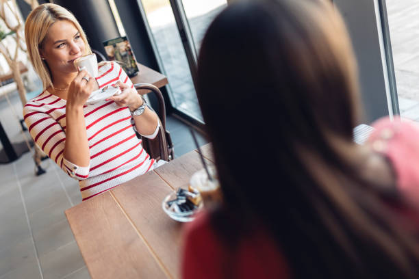 istock Beautiful women drinking coffee and gossiping 875747928