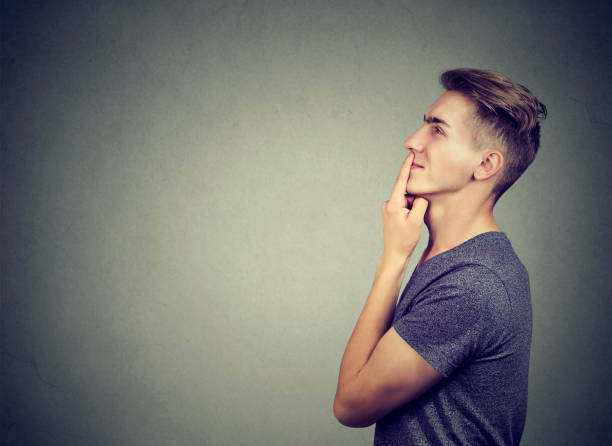 istock Side profile of a thoughtful young man making up his mind looking up smiling 875752536