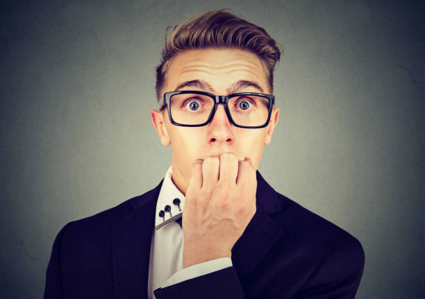 istock Preoccupied anxious business man in glasses biting his fingernails looking at camera 875752976