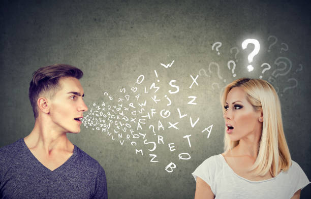 istock Language barrier concept. Handsome man talking to an attractive young woman with question mark 875753150