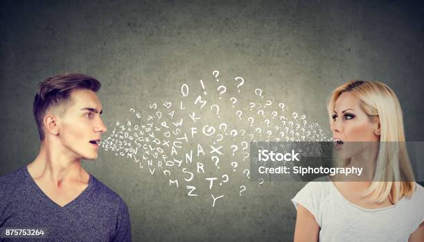 Language Barrier Concept Handsome Man Talking To An Attractive Young Woman With Many Questions Stock Photo - Download Image Now