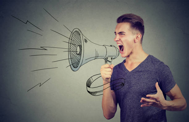 istock Young man screaming into a megaphone making an announcement 875753332