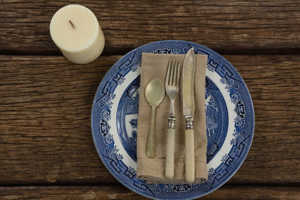 istock Cutlery and napkin on plate with candle 875753484