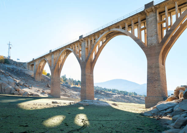 Arid terrain as a result of the drought with old and new bridge background in construction