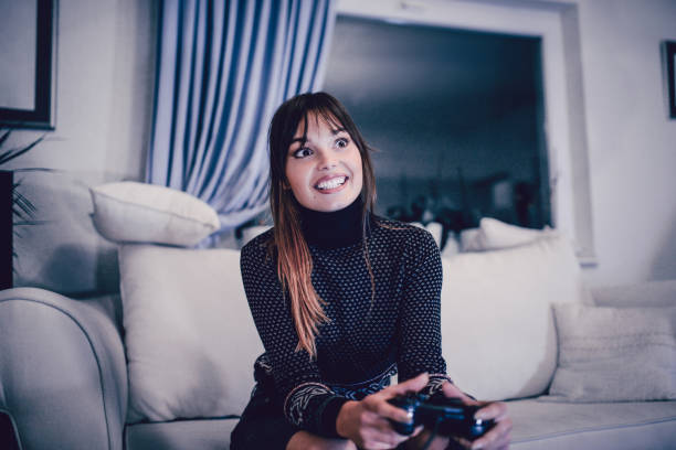 istock Smiling Young Female Playing VIdeo Game at Home 875763542