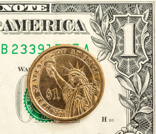istock One dollar coin on the one dollar bill. Close up. 875775786