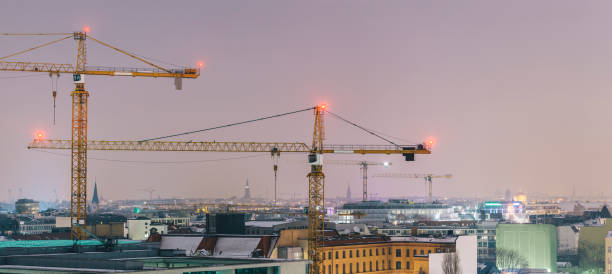 istock Urban skyline with building cranes at night, Berlin, Germany 875775992